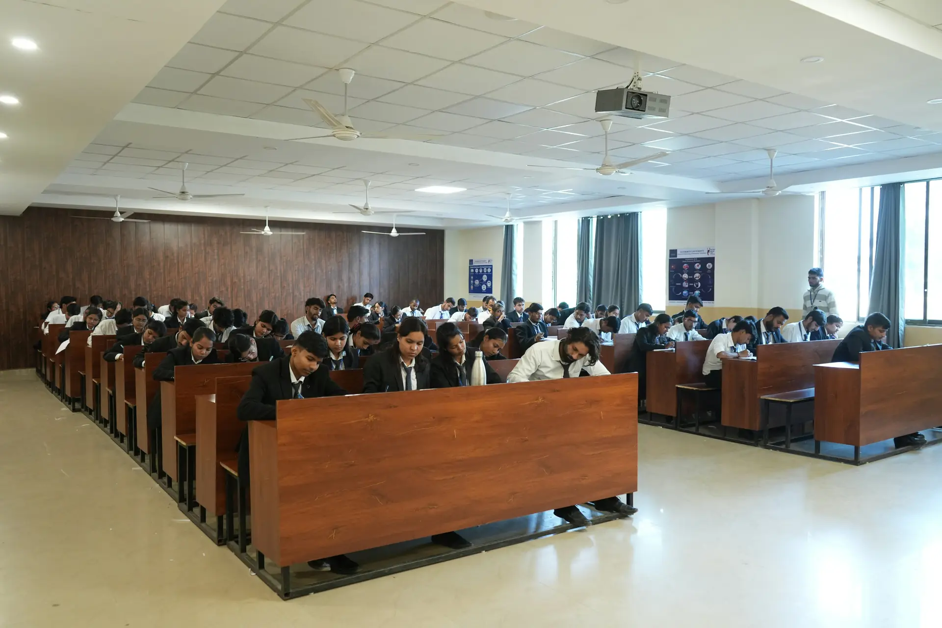 Secondary school learners in uniform completing written classroom work.