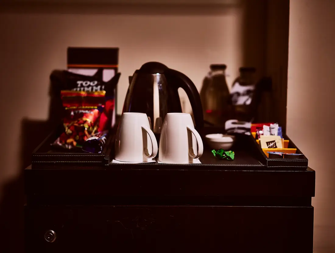 In-room tea and coffee setup with cups, kettle, and refreshments.